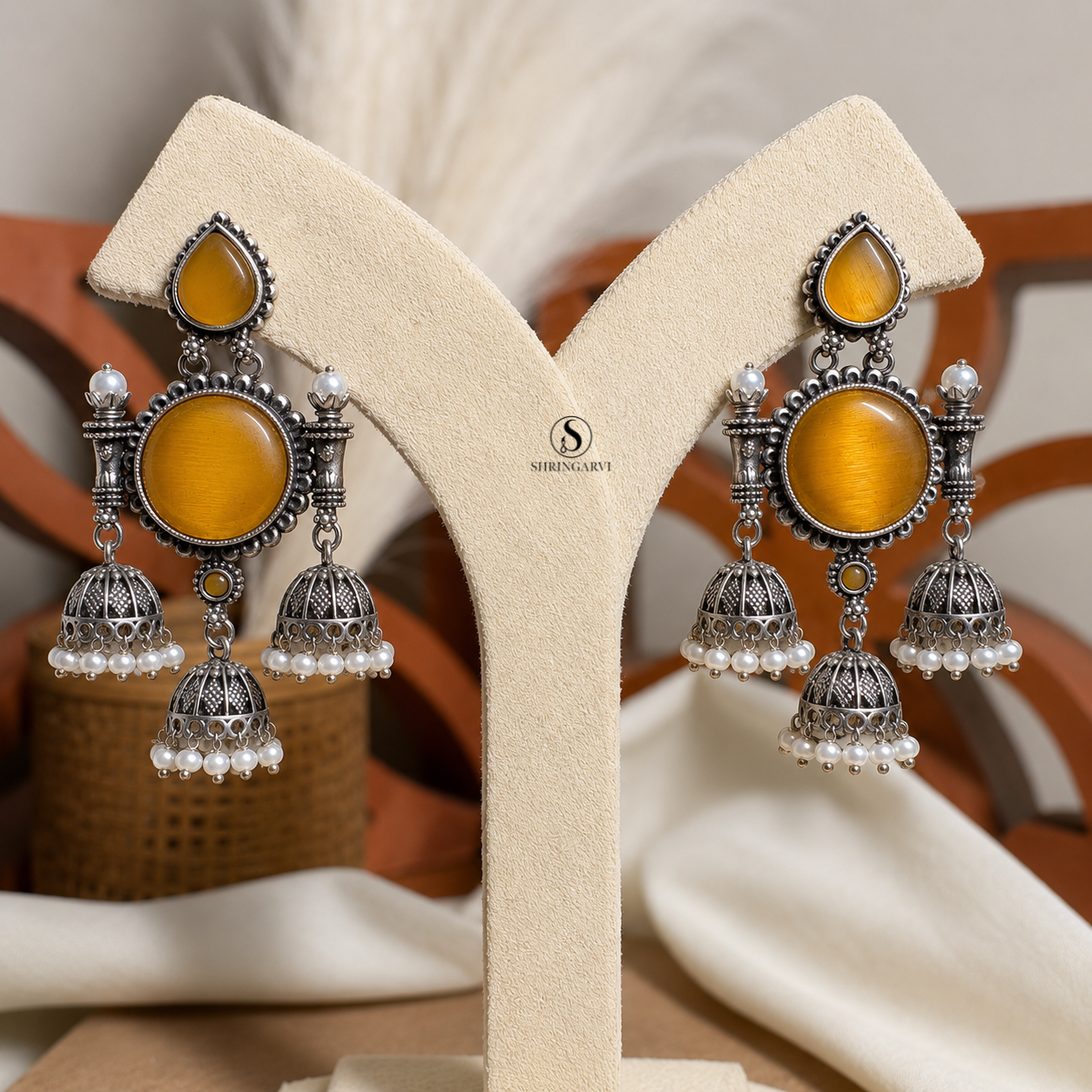 Amber Yellow Monalisa Tripuri Jhumkas handcrafted in oxidised brass featuring Amber Yellow Monalisa stones, pearl-adorned jhumkas, and intricate traditional detailing.