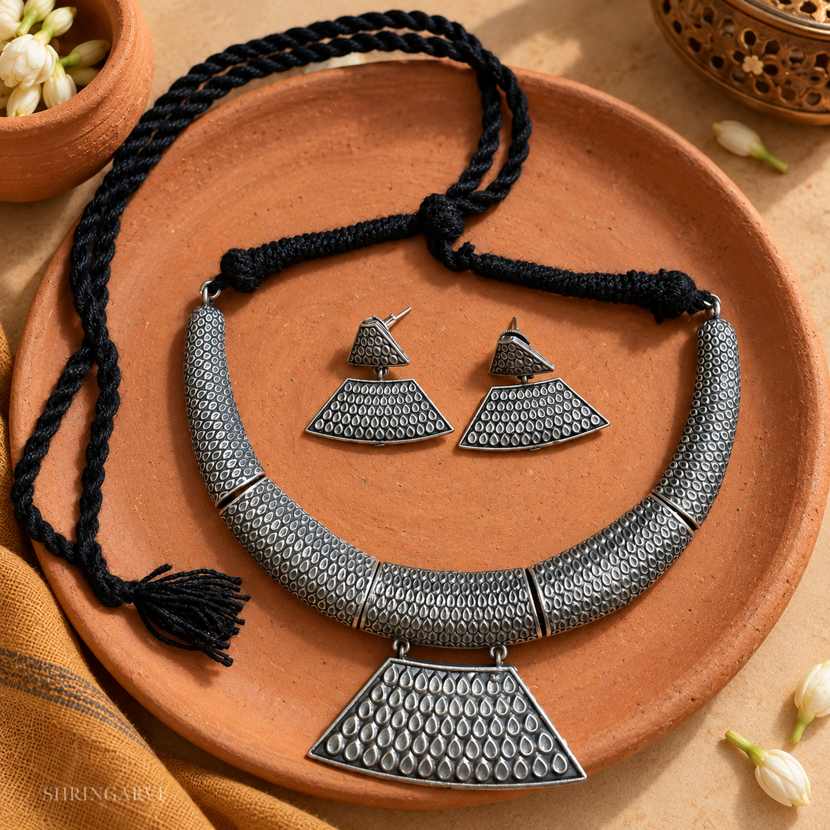Banjaran Tribal oxidised brass necklace set with matching earrings featuring textured tribal motifs and adjustable black thread closure.