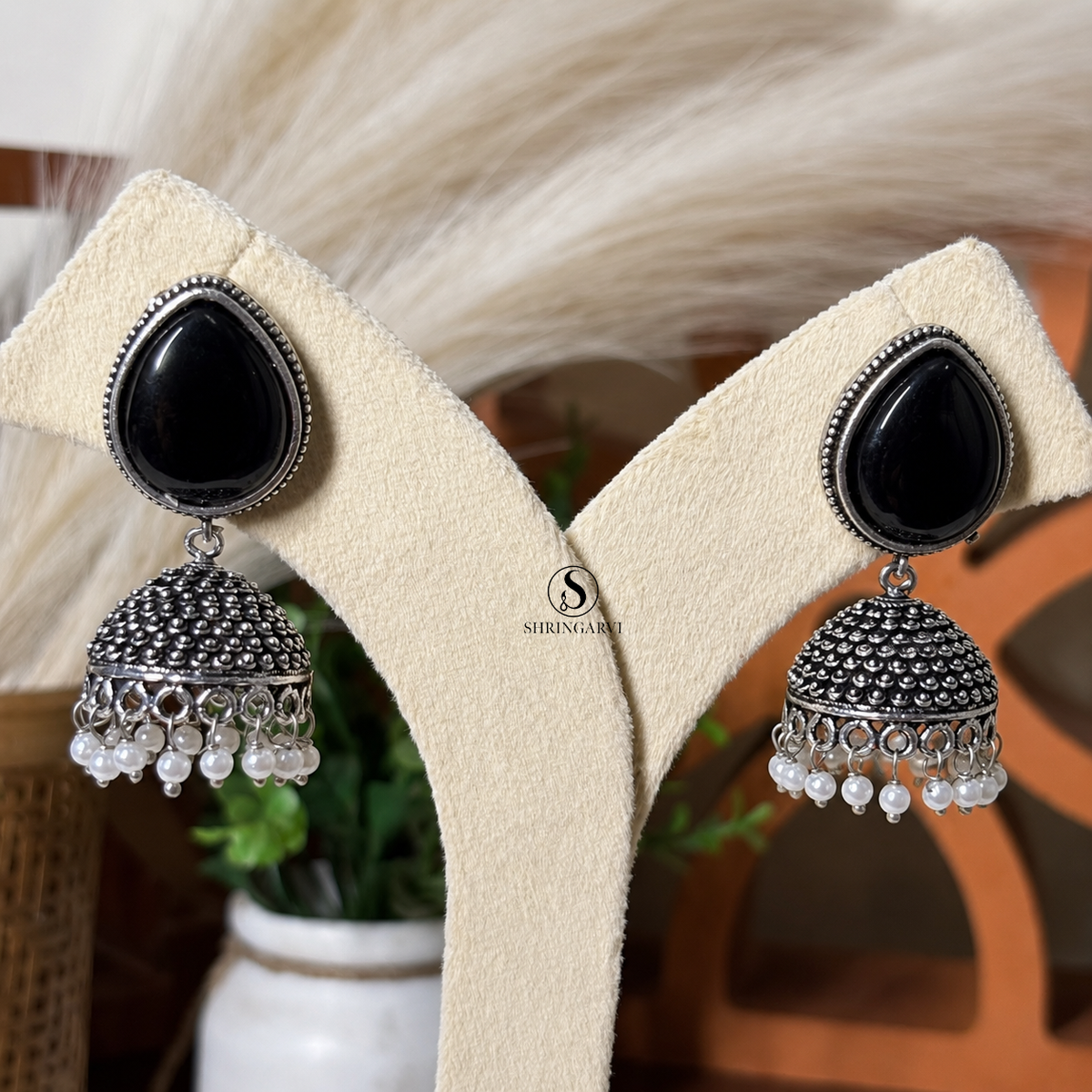 Jhumka with black Monalisa stone, oxidised silver finish jhumka design and pearl bead detailing for festive and ethnic wear.