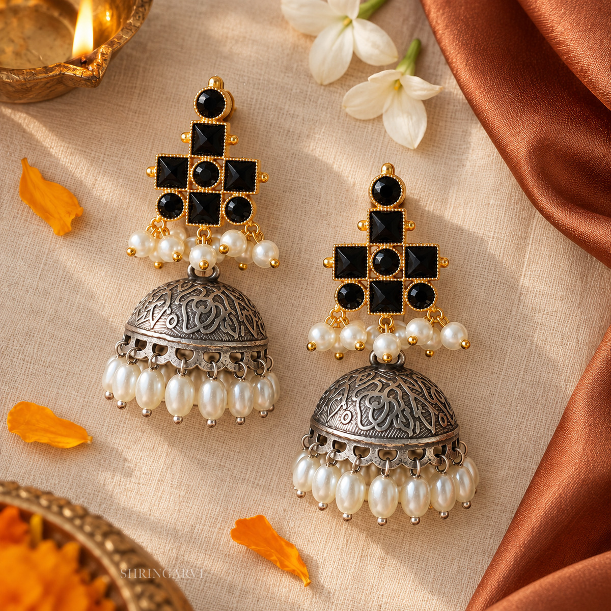 Mrinal Dual Tone Jhumka earrings with black stones, oxidised silver dome, pearl drops, and gold-tone detailing for festive and ethnic wear.
