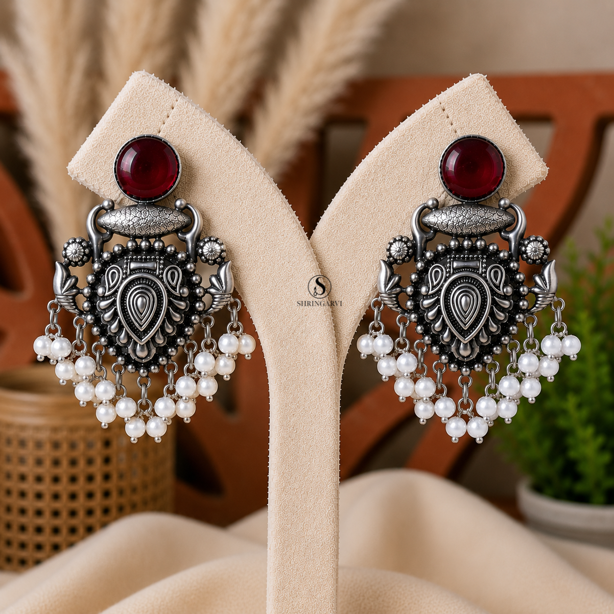 Handcrafted Deep Maroon Raagini Danglers in oxidised brass featuring a ruby red stone, intricate traditional motifs, and elegant pearl drop accents for festive and ethnic styling.