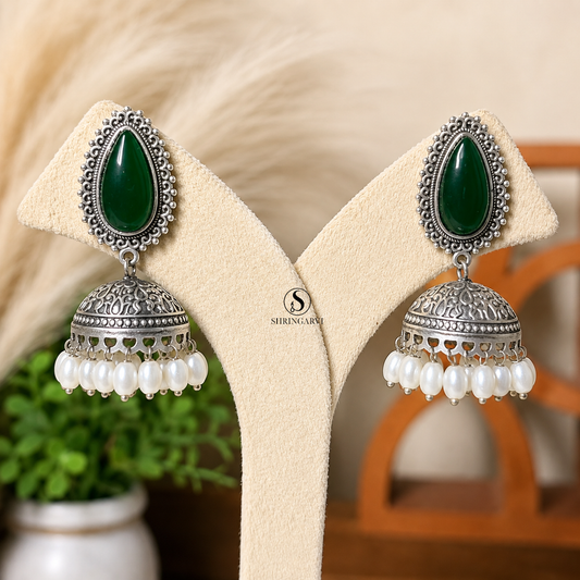 Green Gaura oxidised silver jhumka earrings with green teardrop stone and pearl drop detailing.