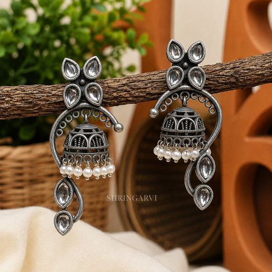 Gunjan Pearl Jhumka with kundan-style stones, oxidised silver finish, curved design, and pearl drop detailing for festive and ethnic wear.