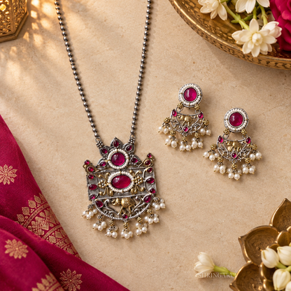 Traditional oxidized silver pendant necklace and earrings set with ruby pink stones and pearl accents for festive and wedding styling.