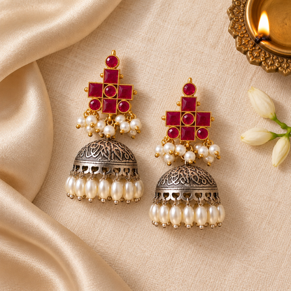 Magenta Mrinal Dual Tone Jhumka earrings with magenta stones, oxidised silver dome, pearl drops, and gold-tone detailing for festive and ethnic wear.