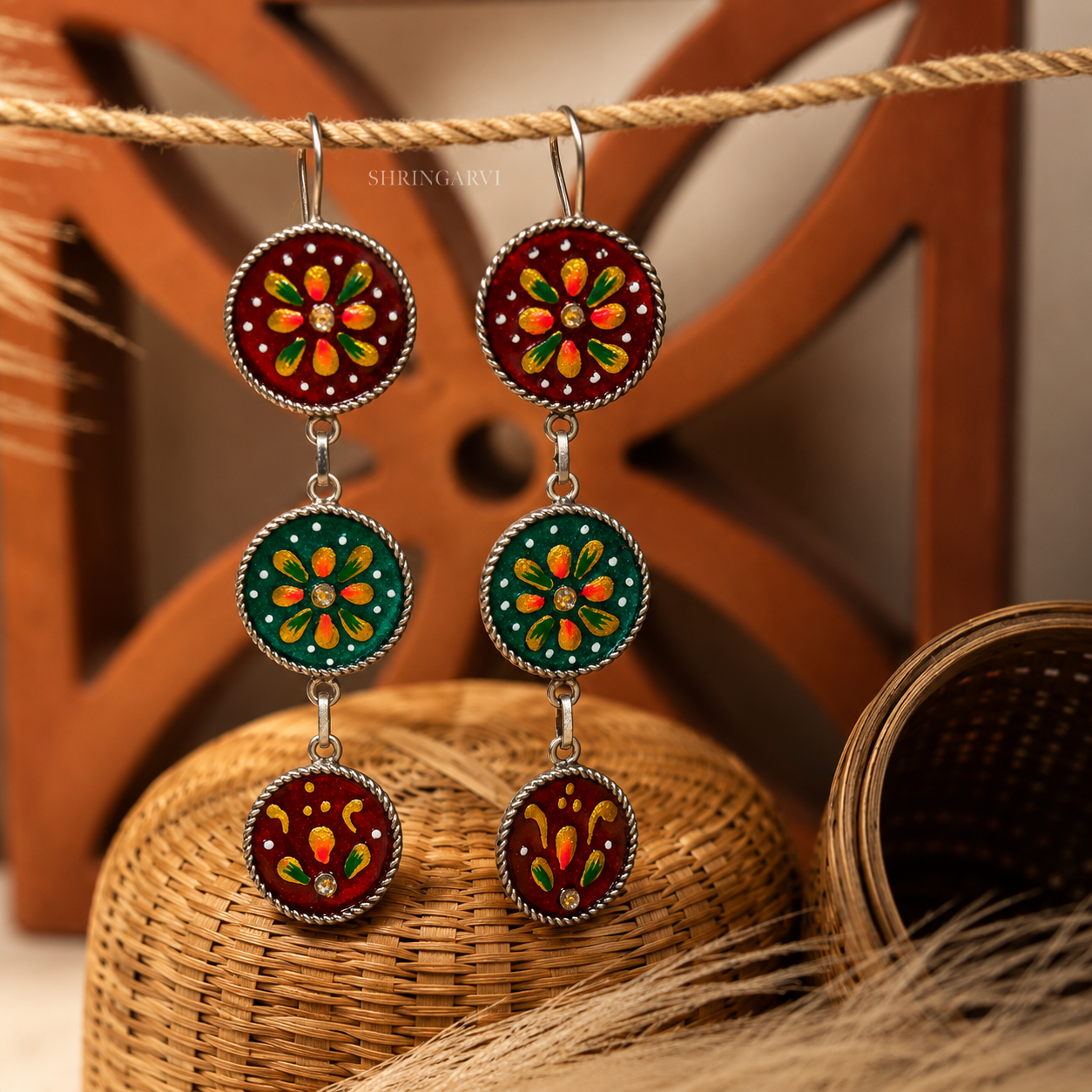 Maroon-Green Kyari Danglers in oxidised brass with handpainted marron and green enamel detailing and three-tier boho design.