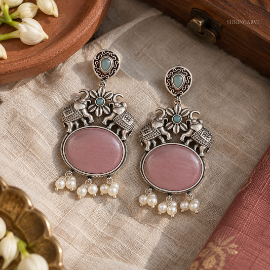 Mauve Riddhi Danglers oxidised earrings with elephant motifs, mauve stone centerpiece, and pearl drops for festive and ethnic wear.
