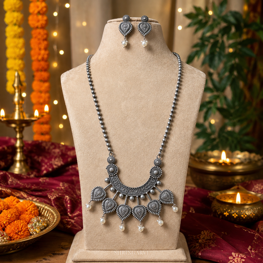 Oxidised silver long statement necklace set with pearl drop detailing and matching earrings displayed on a jewellery bust