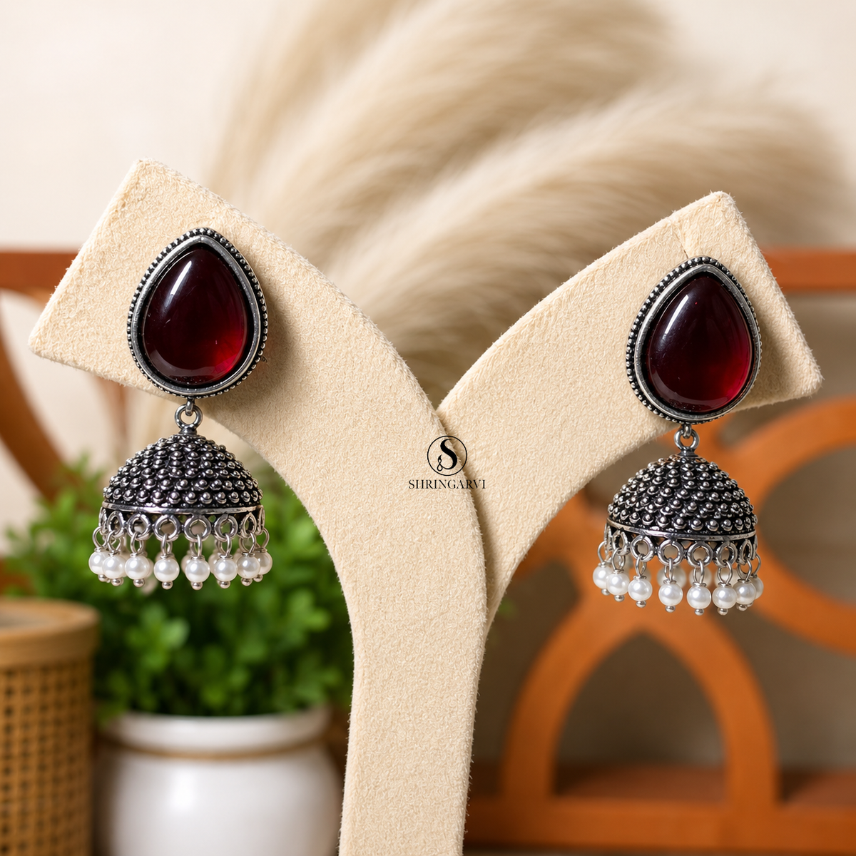 Jhumka with red Monalisa stone, oxidised silver finish jhumka design and pearl bead detailing for festive and ethnic wear.