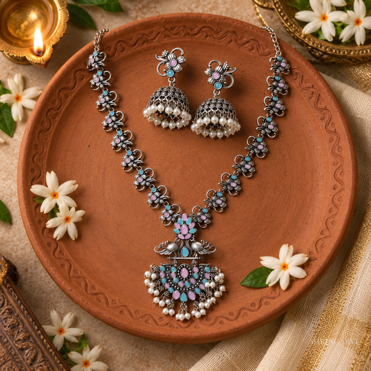 oxidised silver floral necklace set featuring peacock motifs, monalisa stones, pearl detailing, and matching jhumka earrings. 