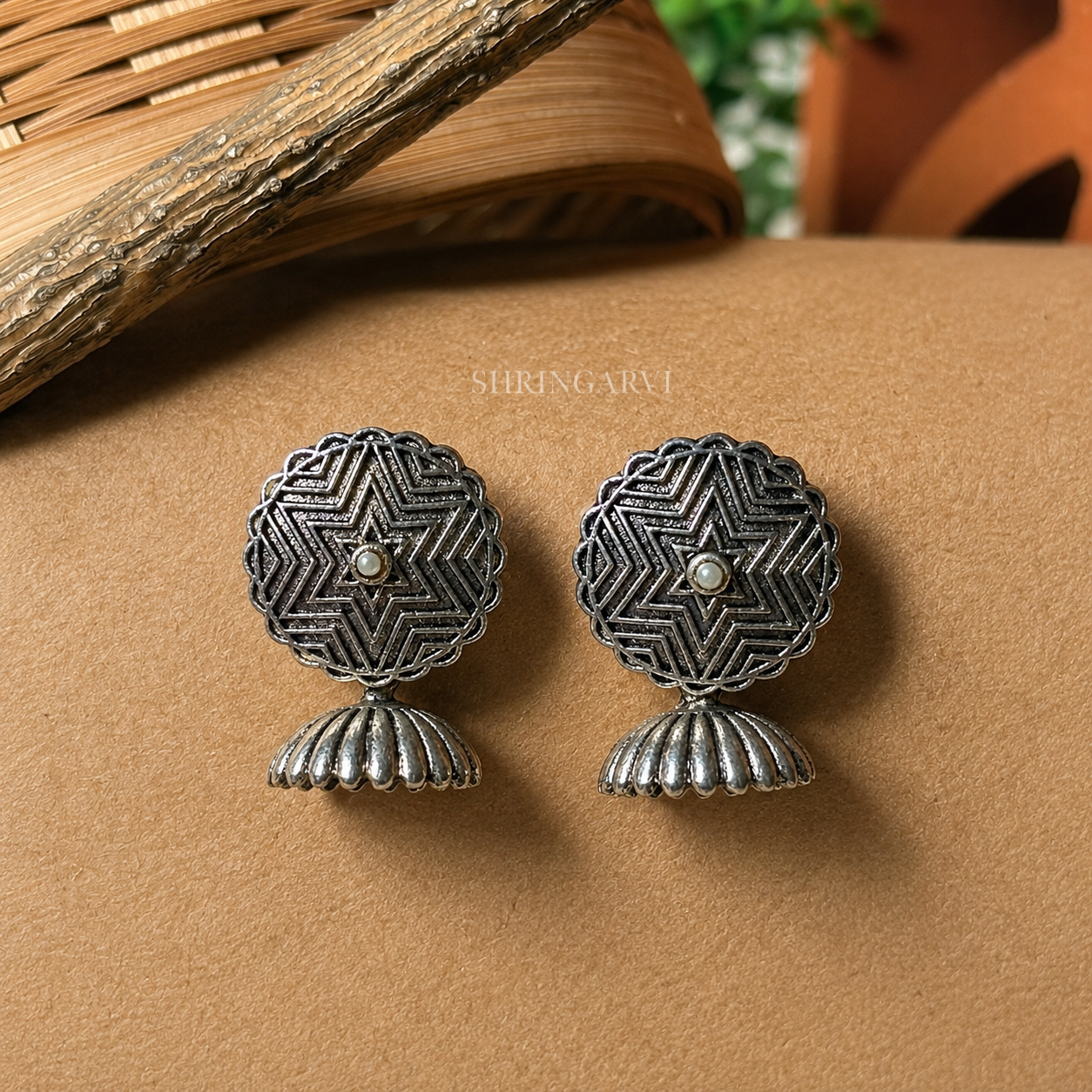 Sitara Mini Jhumki in oxidised brass featuring a star-inspired floral motif with a central pearl and a traditional jhumki drop