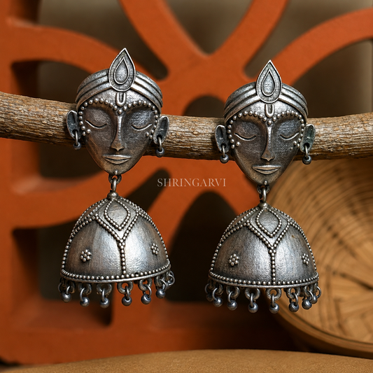 Handcrafted oxidised silver Shyama Jhumka earrings featuring a tribal face motif with dome-shaped jhumka and antique finish